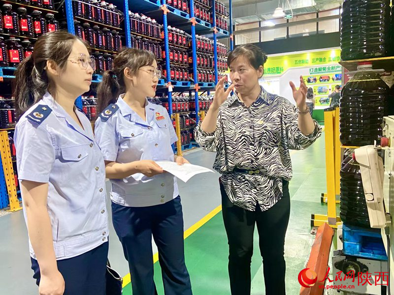 西安市稅務(wù)局青年干部道愛菊糧油集團(tuán)有限公司送政策。人民網(wǎng)記者王晴垣 攝