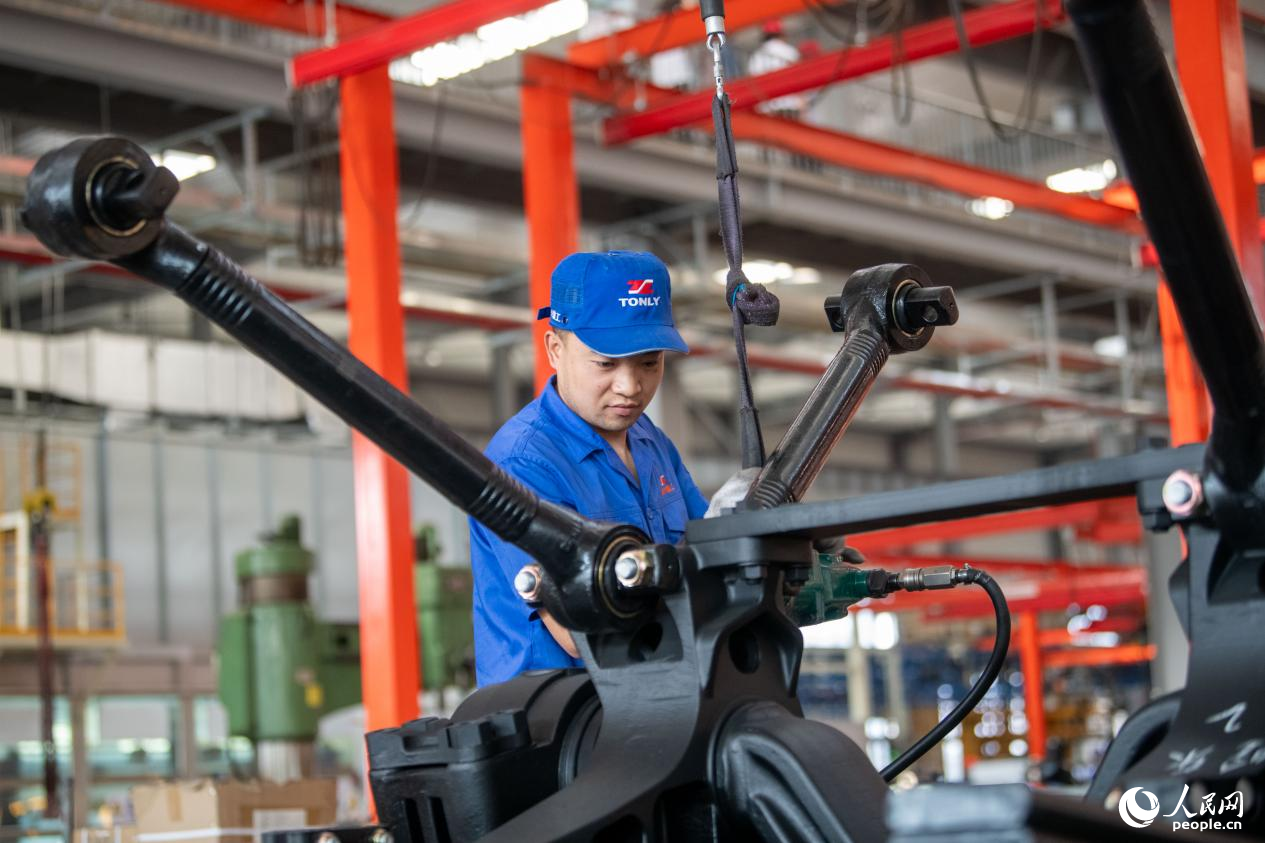 5月14日，在總裝車間，工人正在進行非公路寬體自卸車底盤裝配作業(yè)。人民網(wǎng)記者 翁奇羽攝