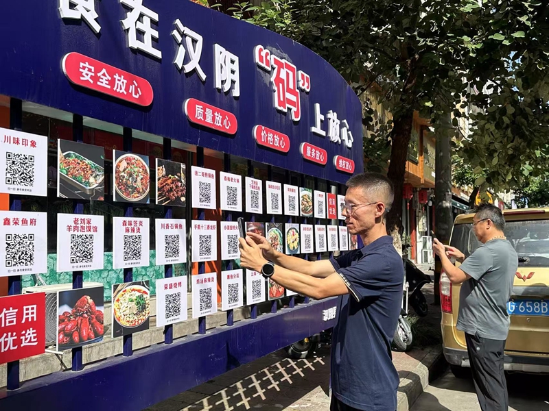 漢陰縣榮盛街頭，顧客食客只需掃碼即可觀看對應餐飲店后廚實況視頻。漢陰縣融媒體中心供圖