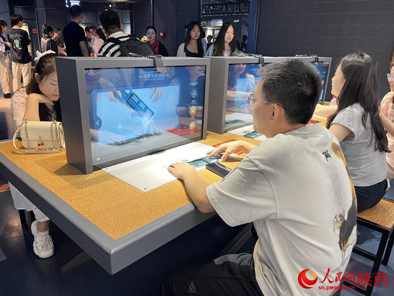 在電影后期制作體驗區(qū)，市民游客體驗電影逐幀制作過程。人民網(wǎng)記者 魏鑫攝