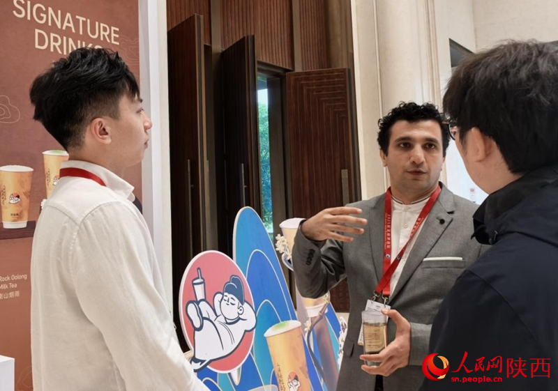 外國(guó)嘉賓和陜西企業(yè)正在交談。