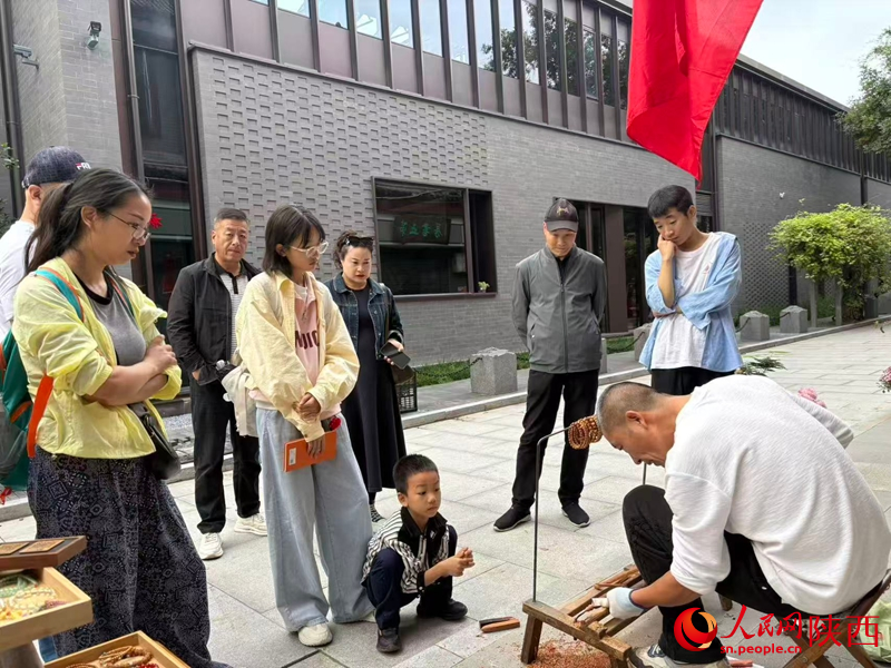 游客正在觀看王小彬手工雕刻過程。人民網(wǎng) 王麗攝